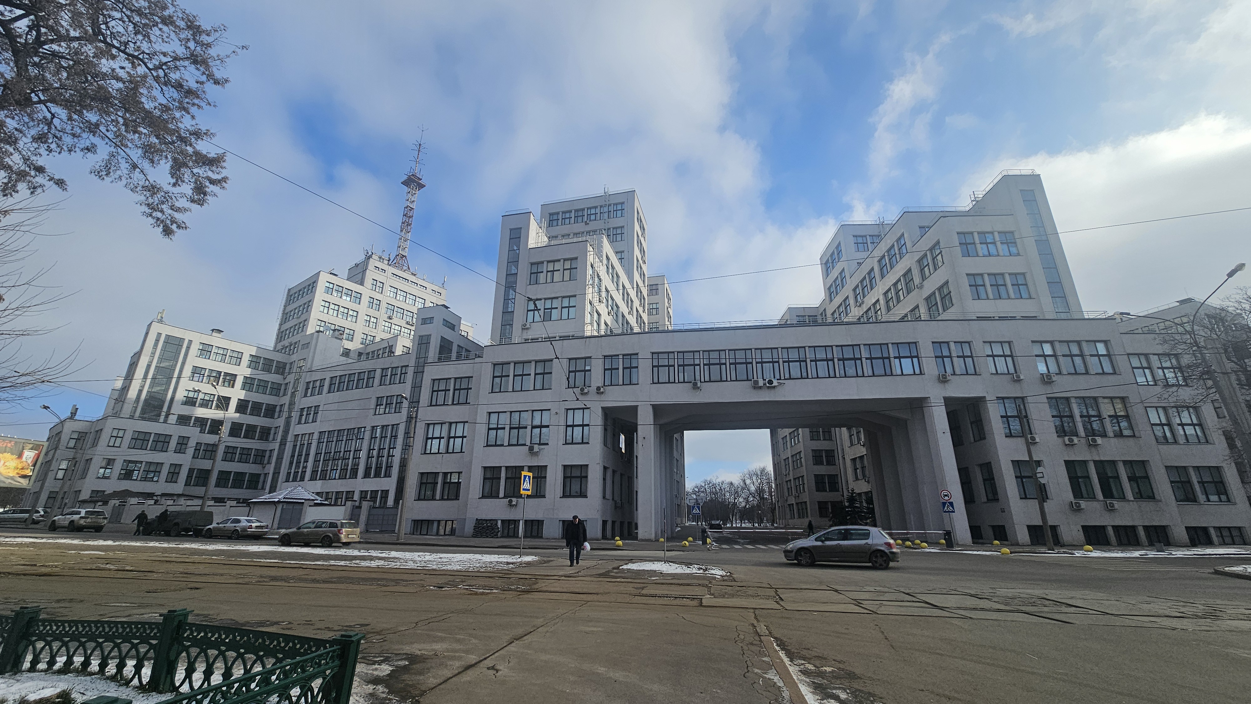 Derzhprom building as seen on February 8th, 2025. Many windows are covered with wooden panels due to russian strikes. Wintry but sunny weather.